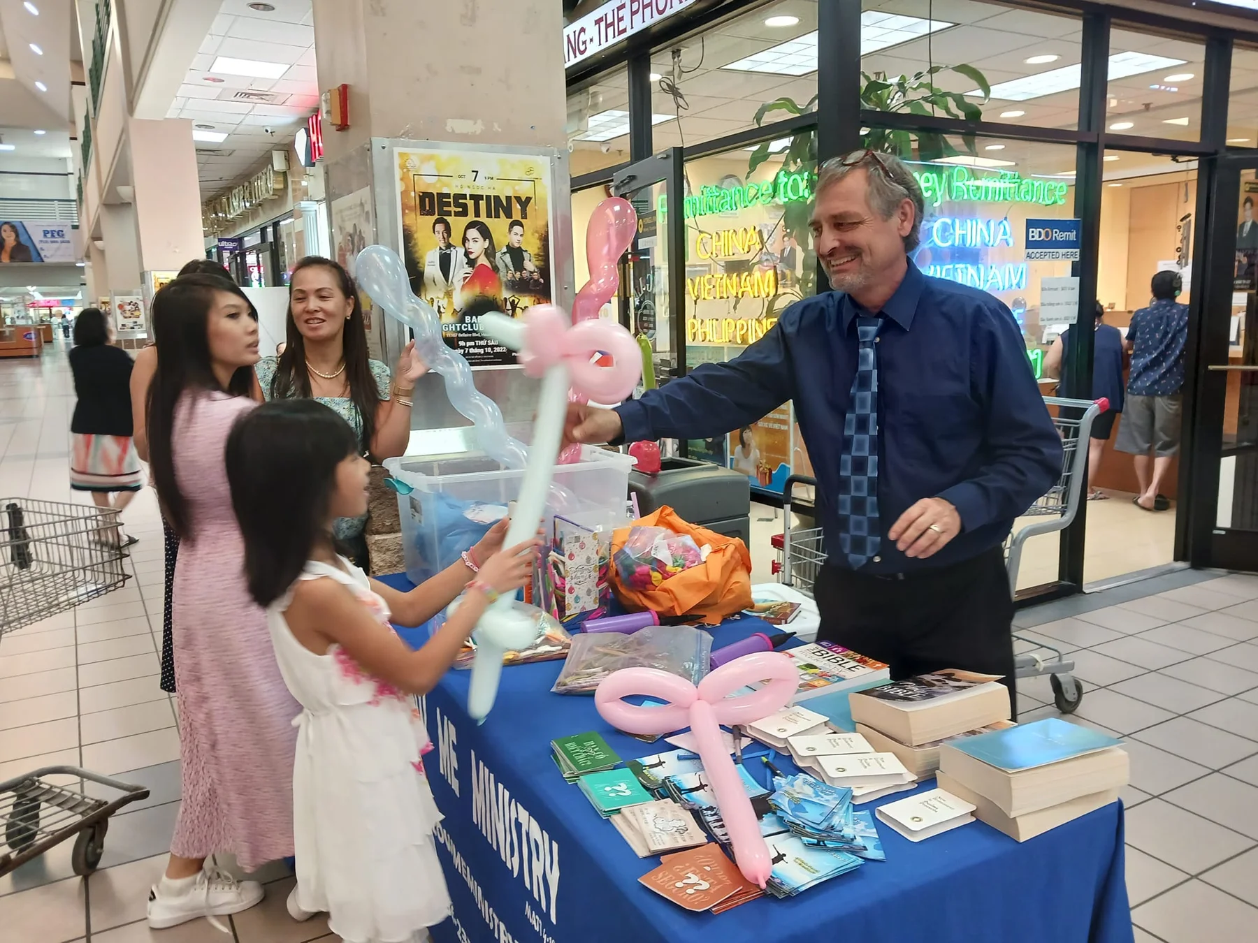 Volunteers and visitors gathered at a Follow Me Ministries outreach table